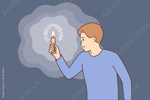 Intrigued man carries burning candle, illuminating path in darkness, hearing rustle or sound