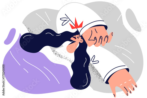 Sick woman lies in bed suffering from migraine puts hand on forehead to get rid of strong headache