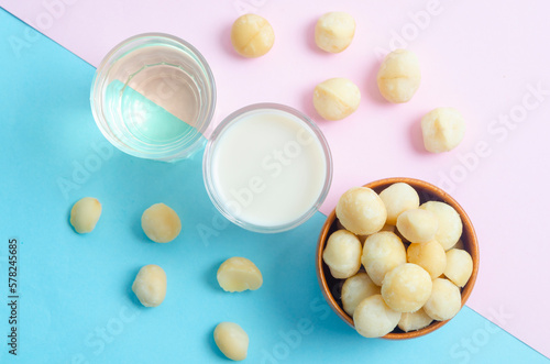 The Macadamia milk, macadamia oil in a glass and a bowl of macadamia nuts on beautiful background. photo
