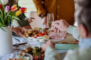 Close up of muligenerational family serving Easter dinner together.
