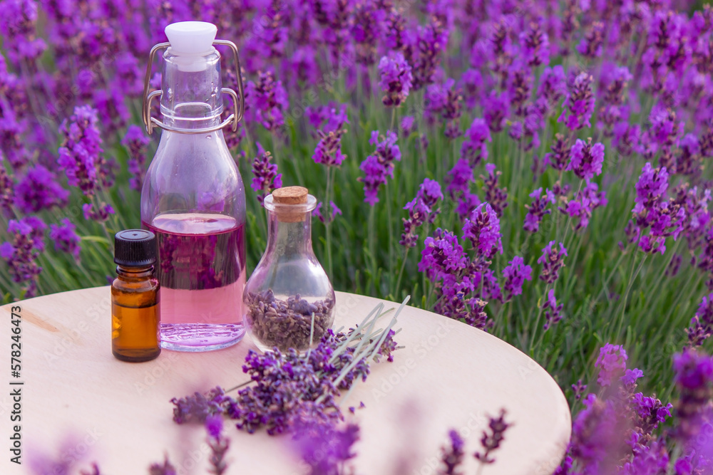 jars with lavender oil, lavender flowers, on the background of a lavender field. jars with lavender oil, lavender flowers, on the background of a lavender field.