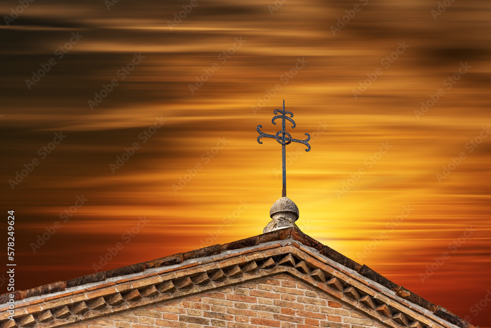 Close-up of a wrought iron religious cross against a beautiful sunset sky. Treviso Cathedral (Duomo o Cattedrale di San Pietro Apostolo), VI-XIX century, Veneto, Italy, Europe.