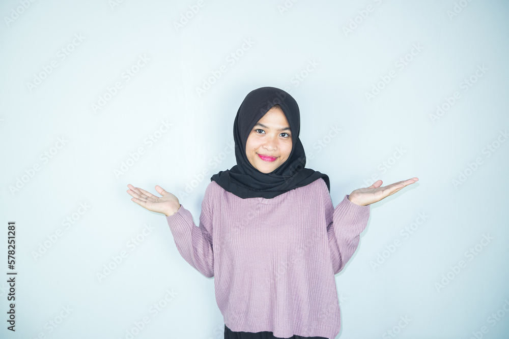 Beautiful asian hijab woman with hands pointing empty space presenting with smiling and confidently Beautiful asian hijab woman with hands pointing empty space presenting with smiling and confidently