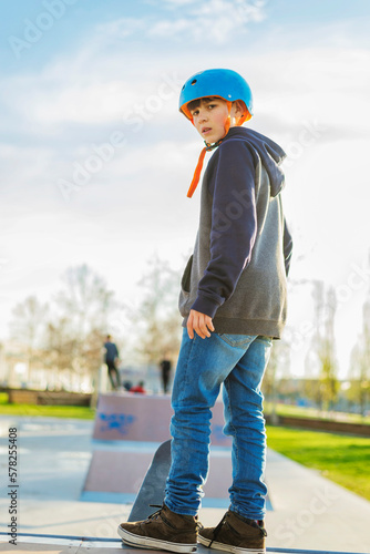 Rear view of young skater standing at skateramp looking back to camera photo