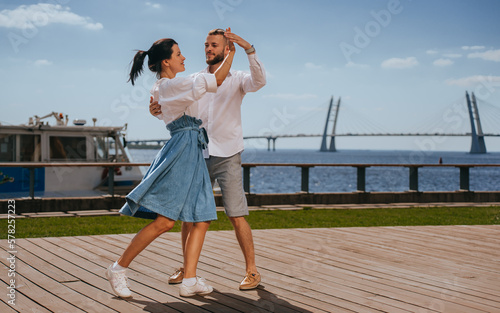 Foto Professional dancers dancing at embankment with view on bay and bridge