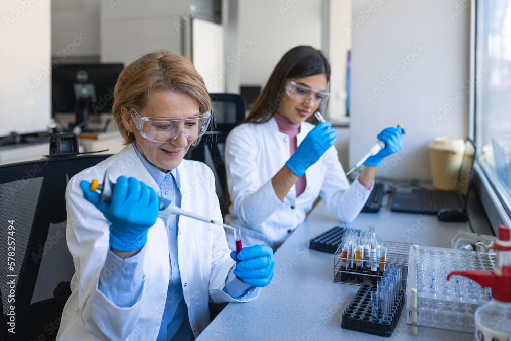 Female Research Scientist Uses Micro Pipette while Working with Test Tubes. People in Innovative Pharmaceutical Laboratory with Modern Medical Equipment for Genetics Research. Female Research Scientist Uses Micro Pipette while Working with Test Tubes. People in Innovative Pharmaceutical Laboratory with Modern Medical Equipment for Genetics Research.