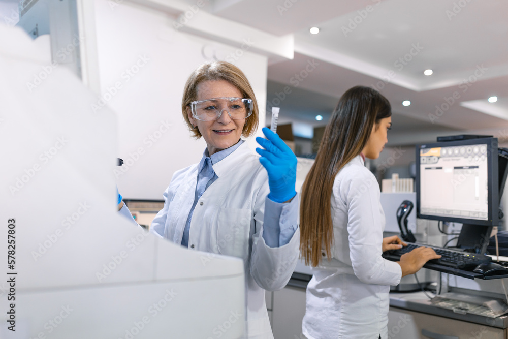 Two Research Scientists Talking about Programming Medical Equipment for Tests. Team of Professionals Doing Pharmaceutical Research in Modern Laboratory Two Research Scientists Talking about Programming Medical Equipment for Tests. Team of Professionals Doing Pharmaceutical Research in Modern Laboratory