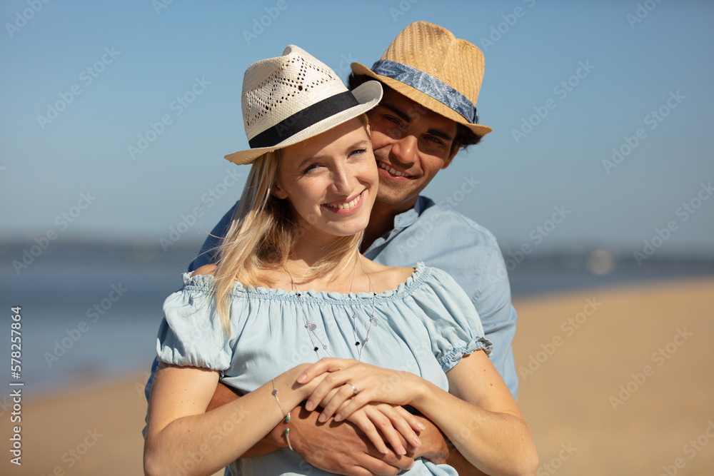 attractive couple cuddling at the beach