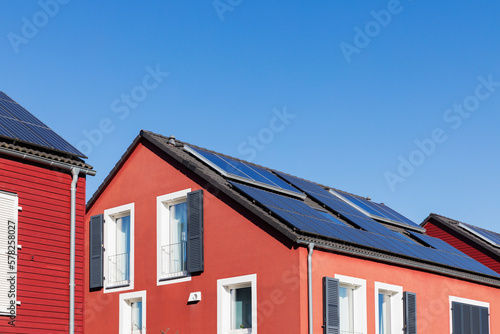 Germany, North Rhine Westphalia, Cologne, Row of red-painted wooden houses with solar roofpanels photo