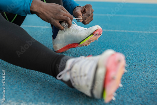 Athlete tying shoes on sports track photo