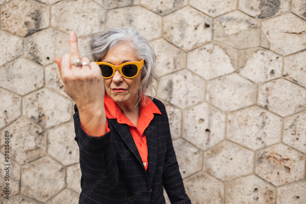 Mature businesswoman gesturing in front of wall Mature businesswoman gesturing in front of wall