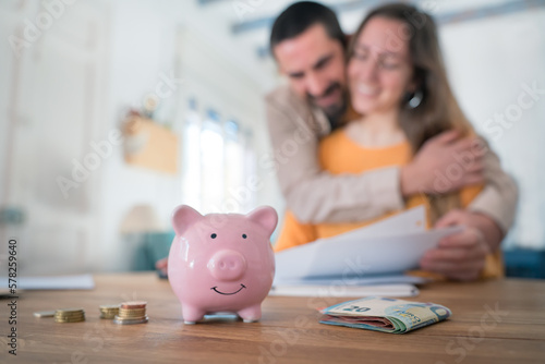Excited young family couple satisfied with successful managing home finances paying domestic bills