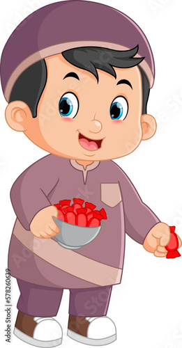 a cute muslim boy brings a big bowl and distributes lots of candy