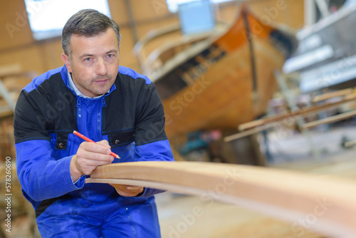 a man is marking the wooden block photo