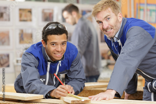 two men measure on the wood photo