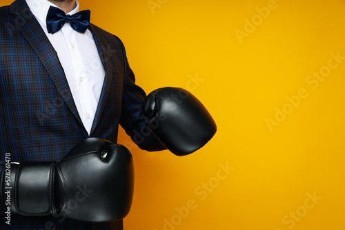 Businessman in boxing gloves on yellow background
