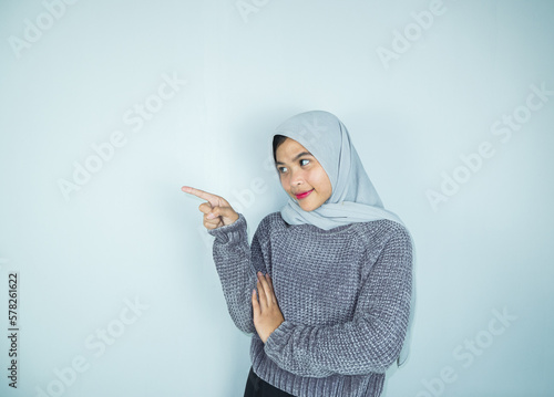 Beautiful asian hijab woman with hands pointing empty space presenting with smiling and confidently