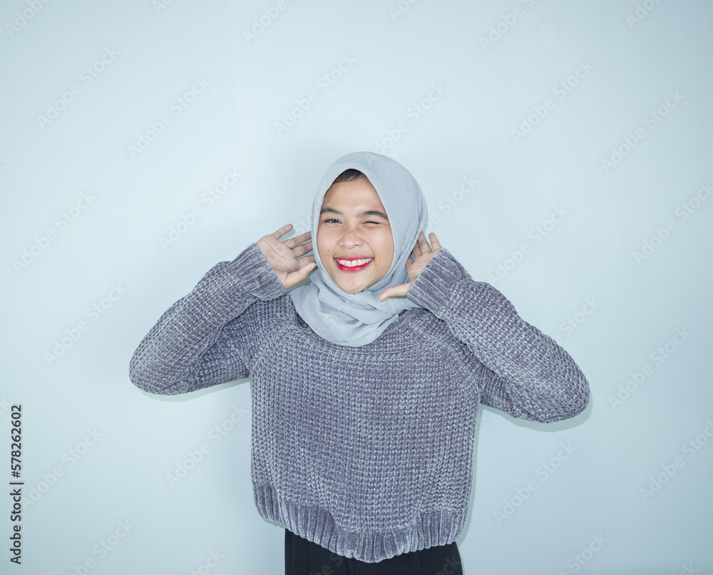 Excited Asian Muslim woman celebrating victory isolated over white background Excited Asian Muslim woman celebrating victory isolated over white background