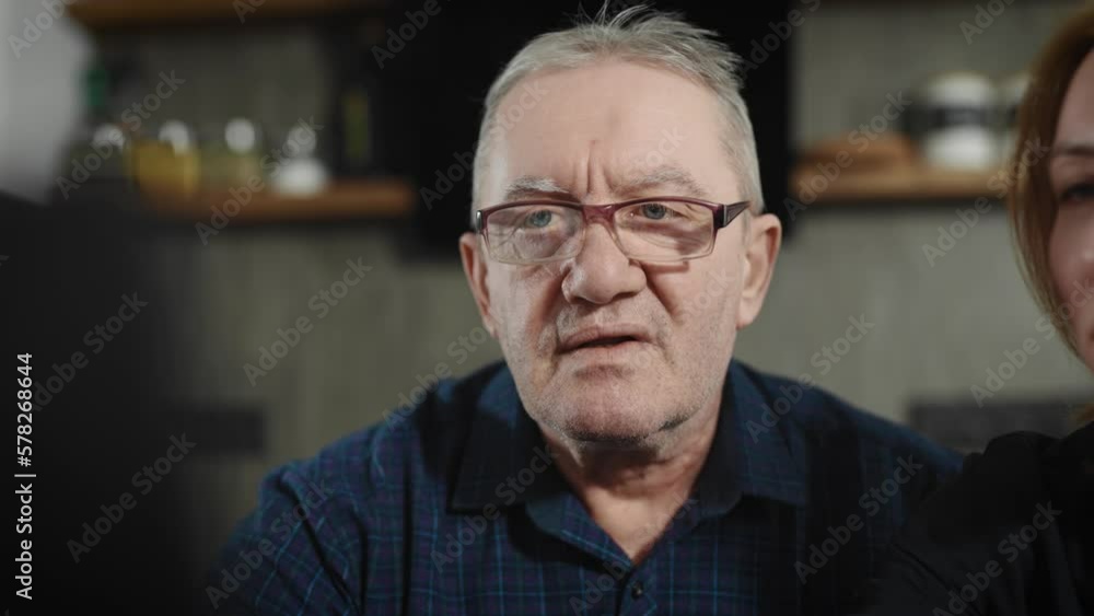 Portrait of an elderly man who is learning how to work with a laptop. The daughter helps her father in mastering computer programs Portrait of an elderly man who is learning how to work with a laptop. The daughter helps her father in mastering computer programs
