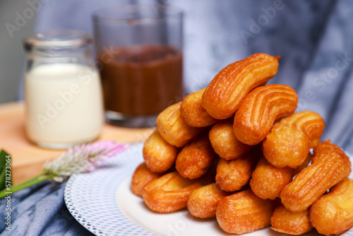 churros, traditional Spanish food served with chocolate and warm milk on the table