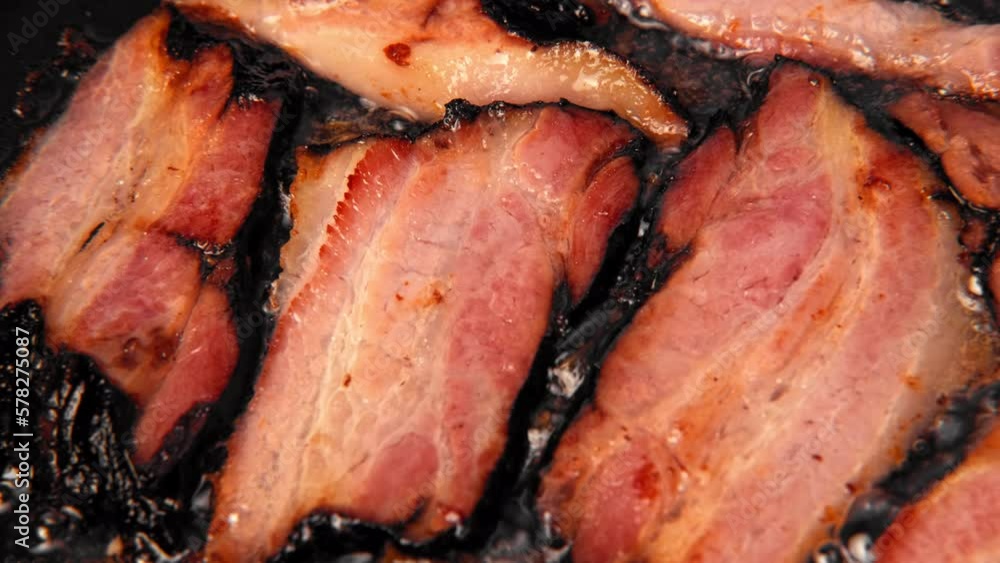 Frying Bacon Slices in a Pan. Crispy Pieces of Delicious Red Thin