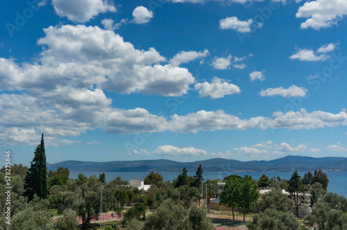 The view from the hotel is of olive trees, the sea, the mountains and the blue sky with clouds. Euboea, Greece.