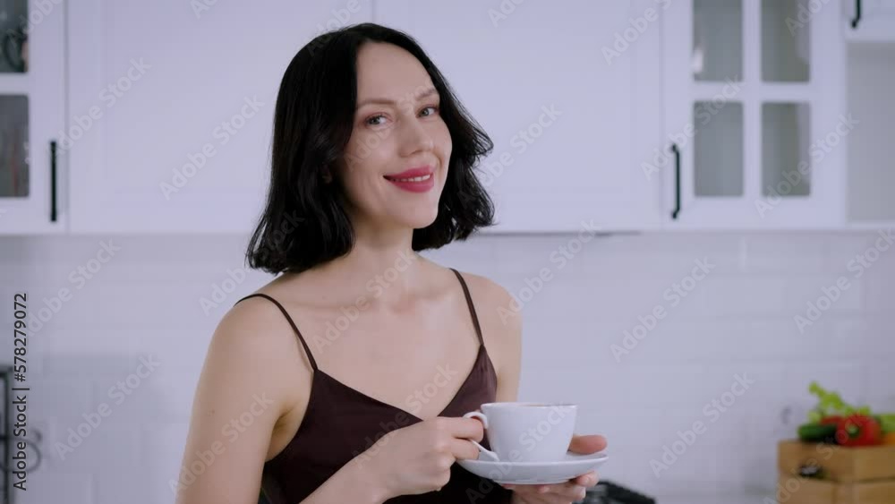 Portrait of a smiling woman looking into the camera and holding a cup of coffee Portrait of a smiling woman looking into the camera and holding a cup of coffee