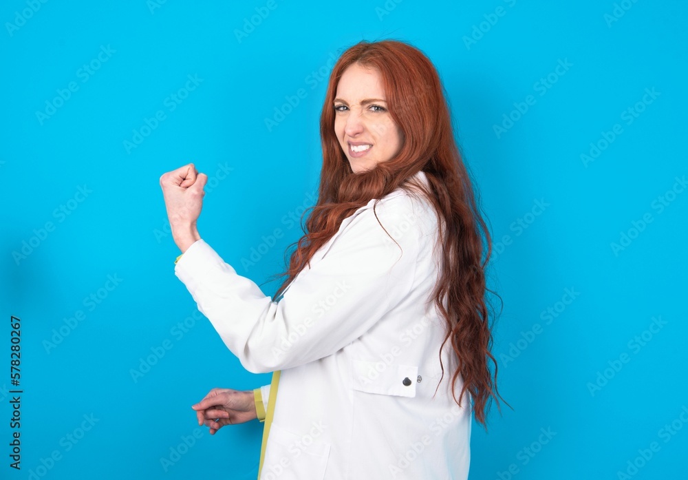 Profile side view portrait young doctor woman wearing medical uniform over blue background celebrates victory Profile side view portrait young doctor woman wearing medical uniform over blue background celebrates victory