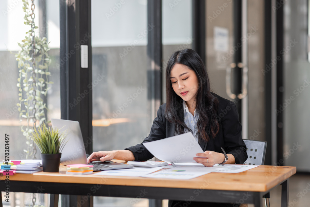 Young business Asian woman using a calculator to Tax deduction planning concept. Businessman calculating business balance prepare loan documents, tax reduction invoices. Young business Asian woman using a calculator to Tax deduction planning concept. Businessman calculating business balance prepare loan documents, tax reduction invoices.