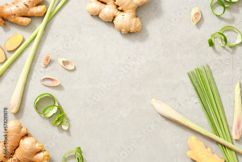 Photography Frame with fresh lemongrass, ginger root and lemon peel on gray background