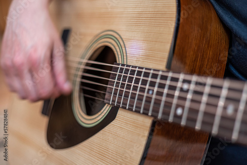 male hands playing acoustic guitar, close up.Acoustic guitar with a beautiful wood . photo