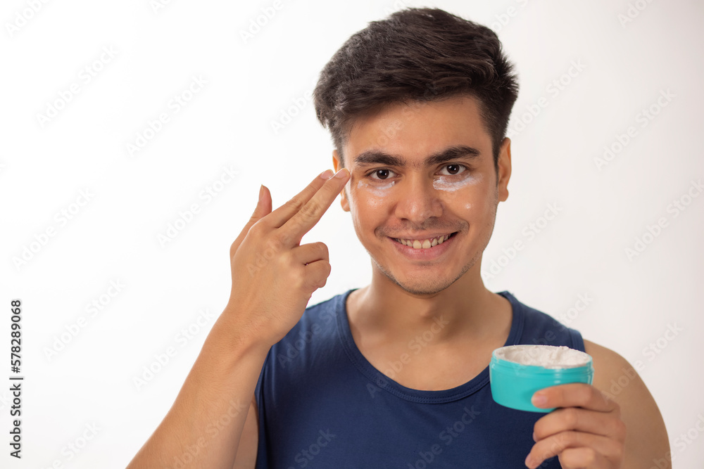 Portrait of cheerful man applying face cream against white background Portrait of cheerful man applying face cream against white background