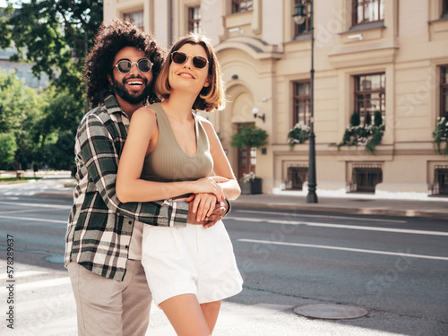 Smiling beautiful woman and her handsome boyfriend. Sexy cheerful family having tender moments in street at sunset. Models hugging. Embracing each other. Love concept. Cheerful, happy, in sunglasses