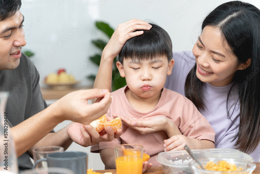 happy family together. Asian parent eating breakfast with little son in the kitchen. happy family together. Asian parent eating breakfast with little son in the kitchen.