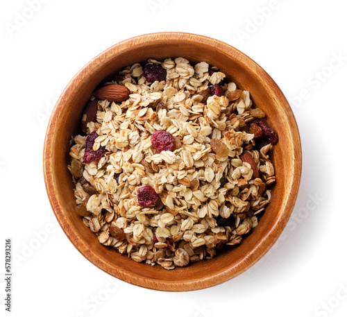 Granola with nuts and raisins in a wooden plate on a white background. Top view