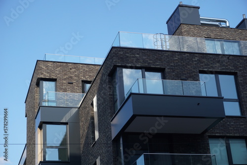 Modern residential building with balconies and dark brick facade. Real estate and housing issues concept.