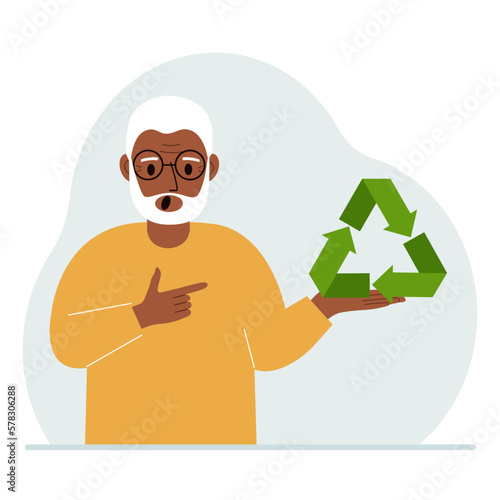 A old man is holding a green recycle, recycling or ecology sign in his hands.
