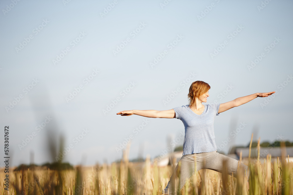 Staying strong, supple and flexible. an attractive woman doing yoga in a crop field. Staying strong, supple and flexible. an attractive woman doing yoga in a crop field.