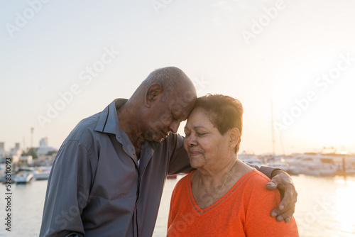 Senior couple standing at the beach together hugging
