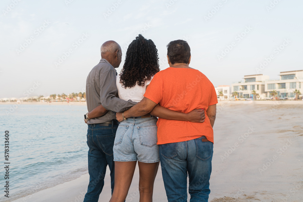 Senior couple with their granddaughter walking at the beach together Senior couple with their granddaughter walking at the beach together