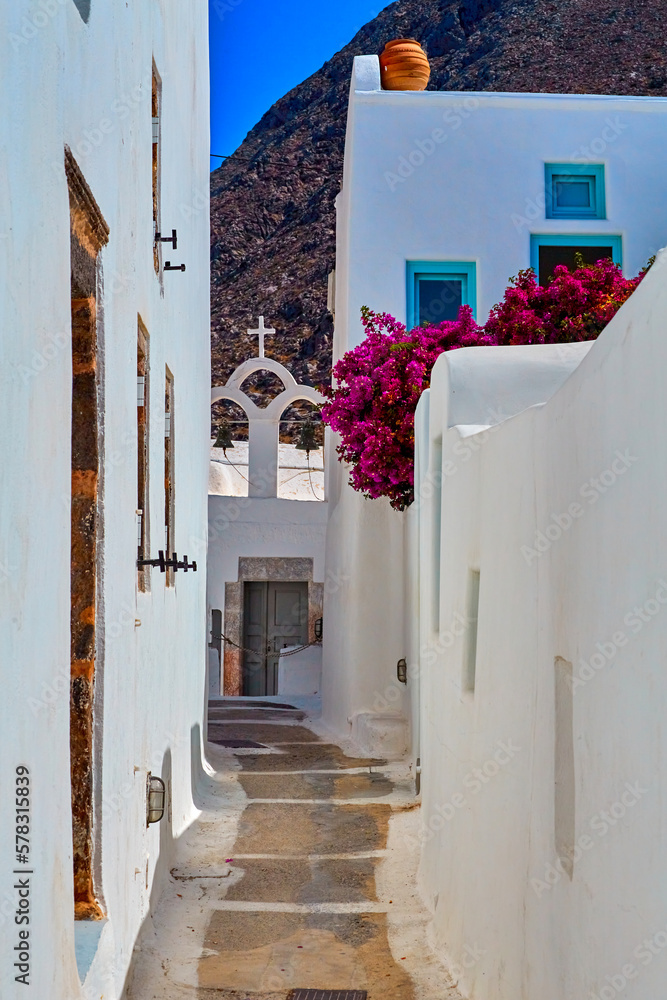 Fototapeta premium In the narrow streets of Emporio village, Santorini, Greece. The winding pathways in Kasteli, the castle are very narrow with steep stairs and very narrow doors and windows.