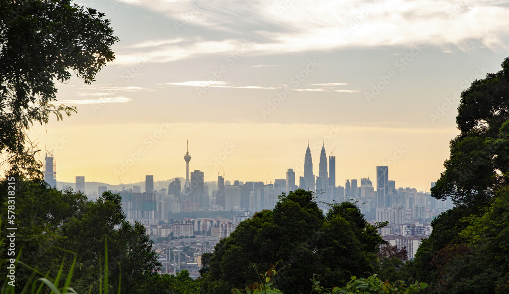 Skyline of Kuala Lumpur viewed at sunset and framed by thick jungle