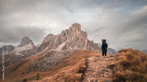 Woman enjoying the top of the mountain, overlooking a snowy range, Dolomites Italy