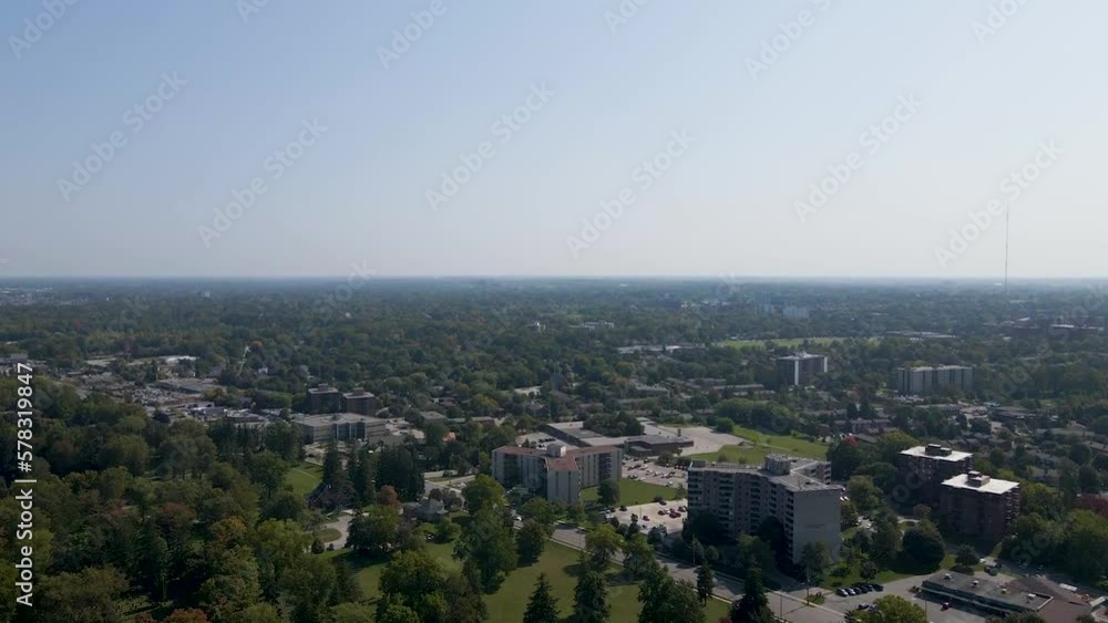 Flying over a sunny and hazy London suburb showing trees and apartment buildings. Flying over a sunny and hazy London suburb showing trees and apartment buildings.
