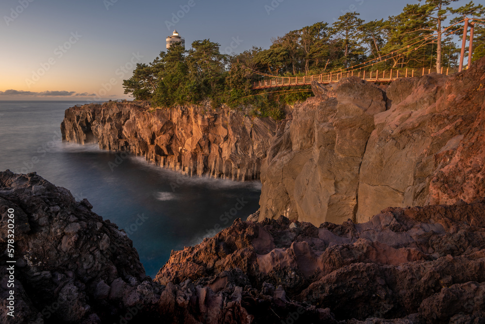 Rocky coastline and suspension bridge by jogasaki lighthouse Izu Japan