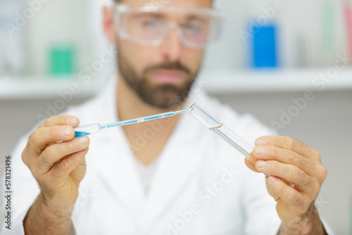 portrait of a man holding a pipette