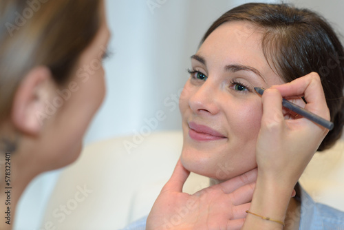 portrait of beautiful woman putting makeup on