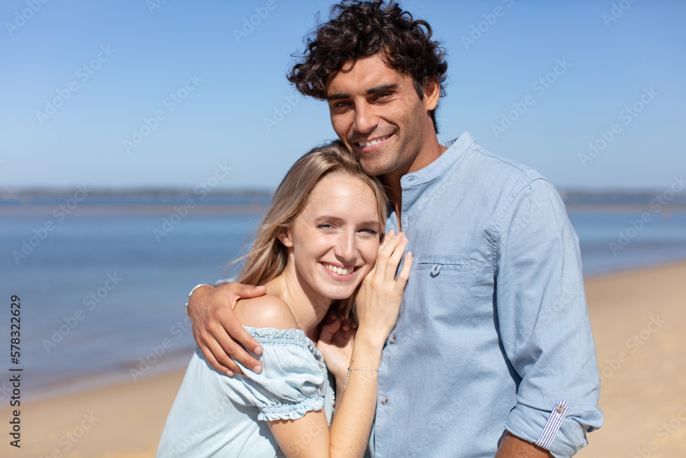 happy young couple laughing and hugging on the beach happy young couple laughing and hugging on the beach