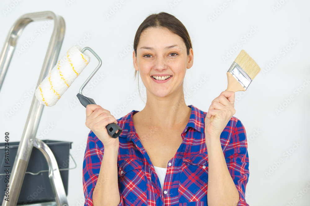 woman holding regular brush and roller brush woman holding regular brush and roller brush