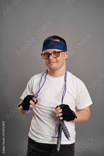 Man with down syndrome with sporty clothes on gray background